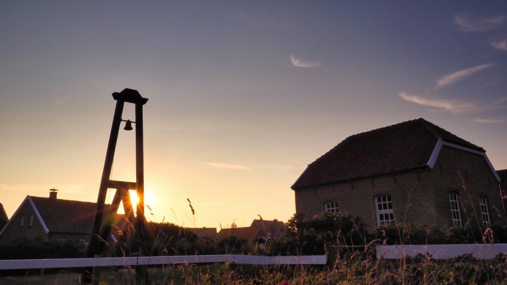 Inselglocke neben der alten Inselkirche auf der ostfriesischen Insel Baltrum. Zeigt gut die Qualität des Objektivs bei extremem Gegenlicht. Zudem erzeugt die Blende in geschlossenem Zustand einen schönen Stern.