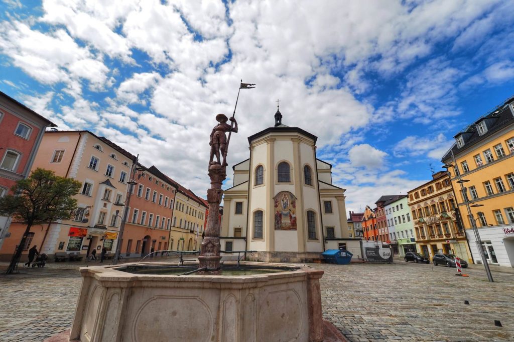 Traunstein, Stadtplatz mit Lindlbrunnen und Stadtparrkirche St. Oswald. Aufgenommen mit dem Olympus Weitwinkel Pro 7-14mm/2,8.