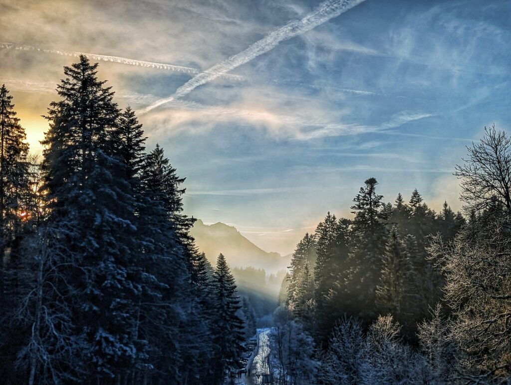 Winterlicher Nebel zieht ins Flußtal bei Sonnenuntergang im Chiemga